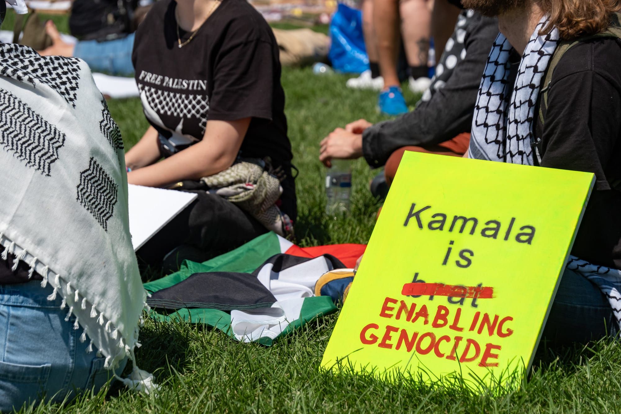 Protest sign says, "Kamala is enabling genocide" / Liberals stepped over the bodies of Palestinian women to vote for Harris