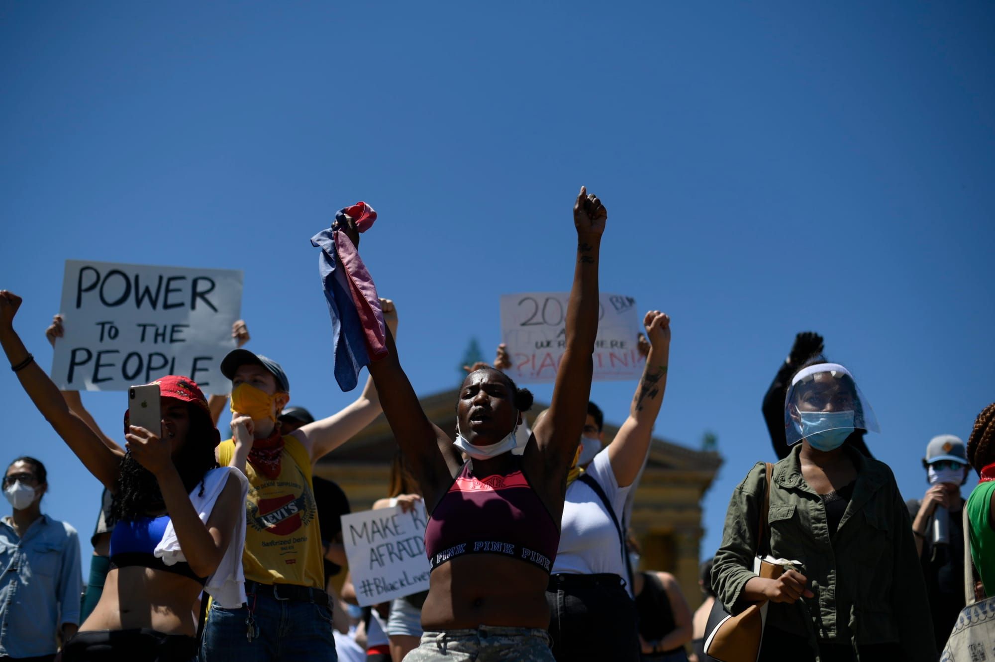 front view of people marching with arms in the air