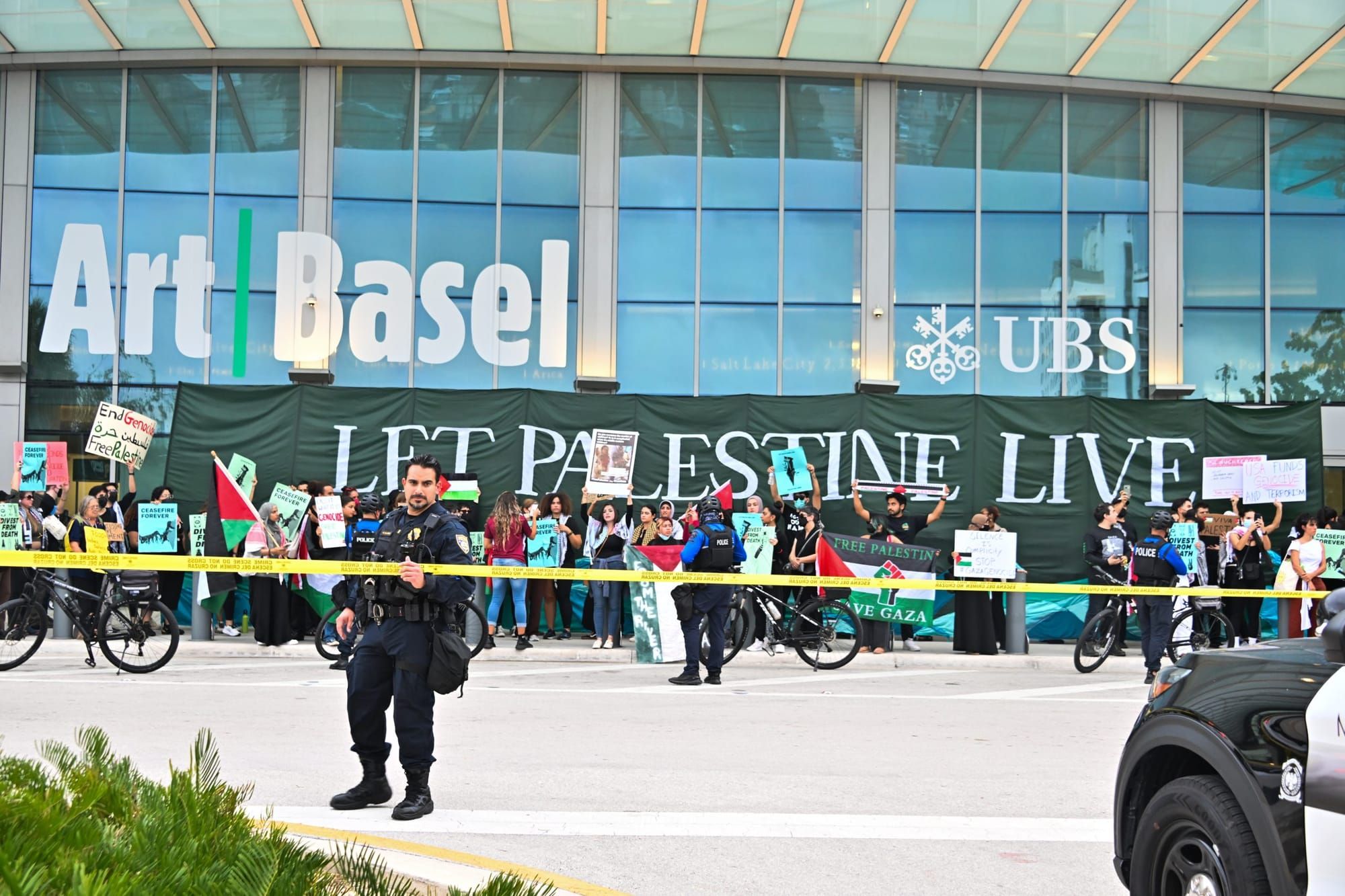 Palestine solidarity protesters display "Let Palestine Live" sign in front of Art Basel