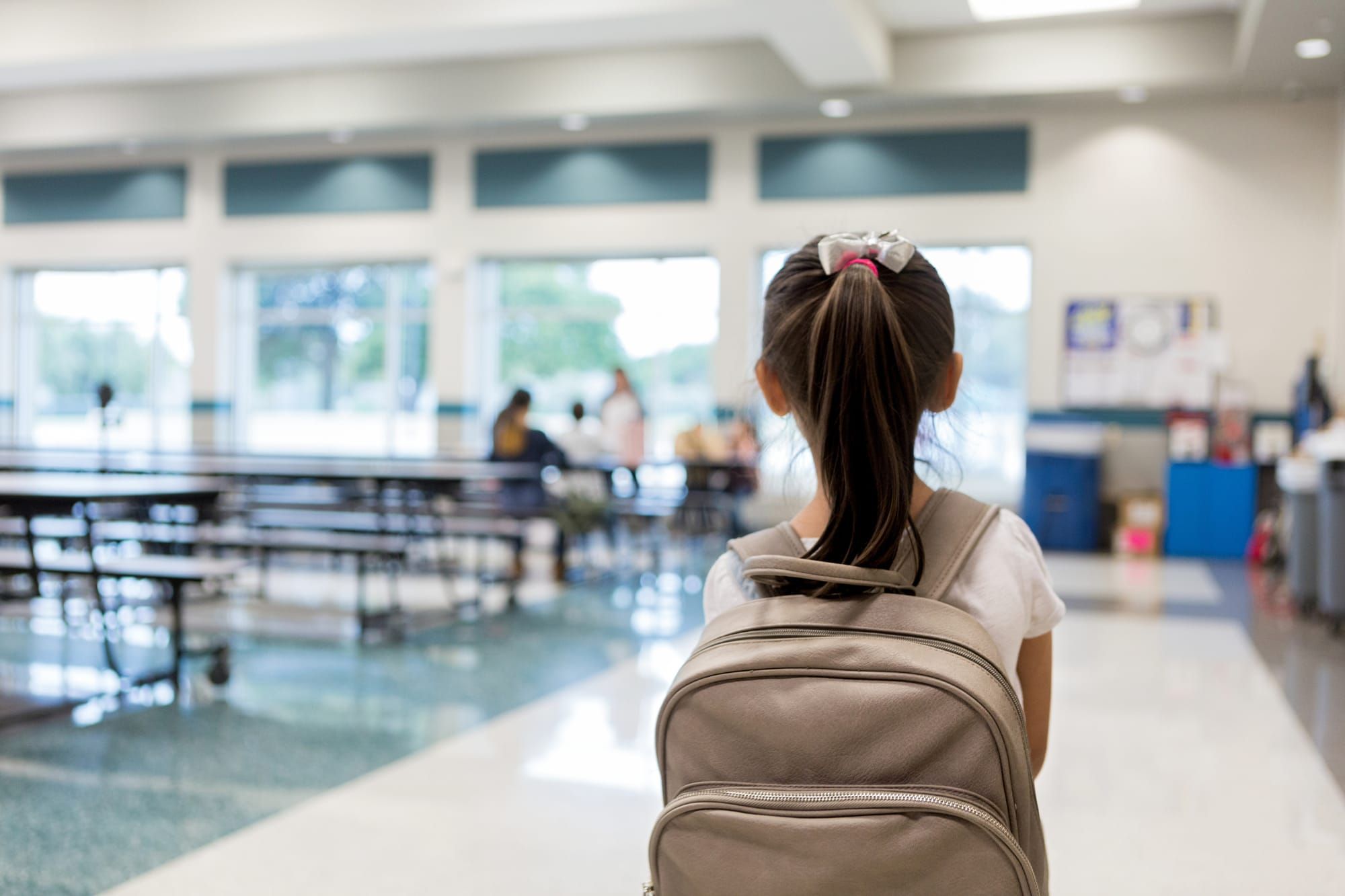 Elementary schoolgirl enters the school cafeteria.