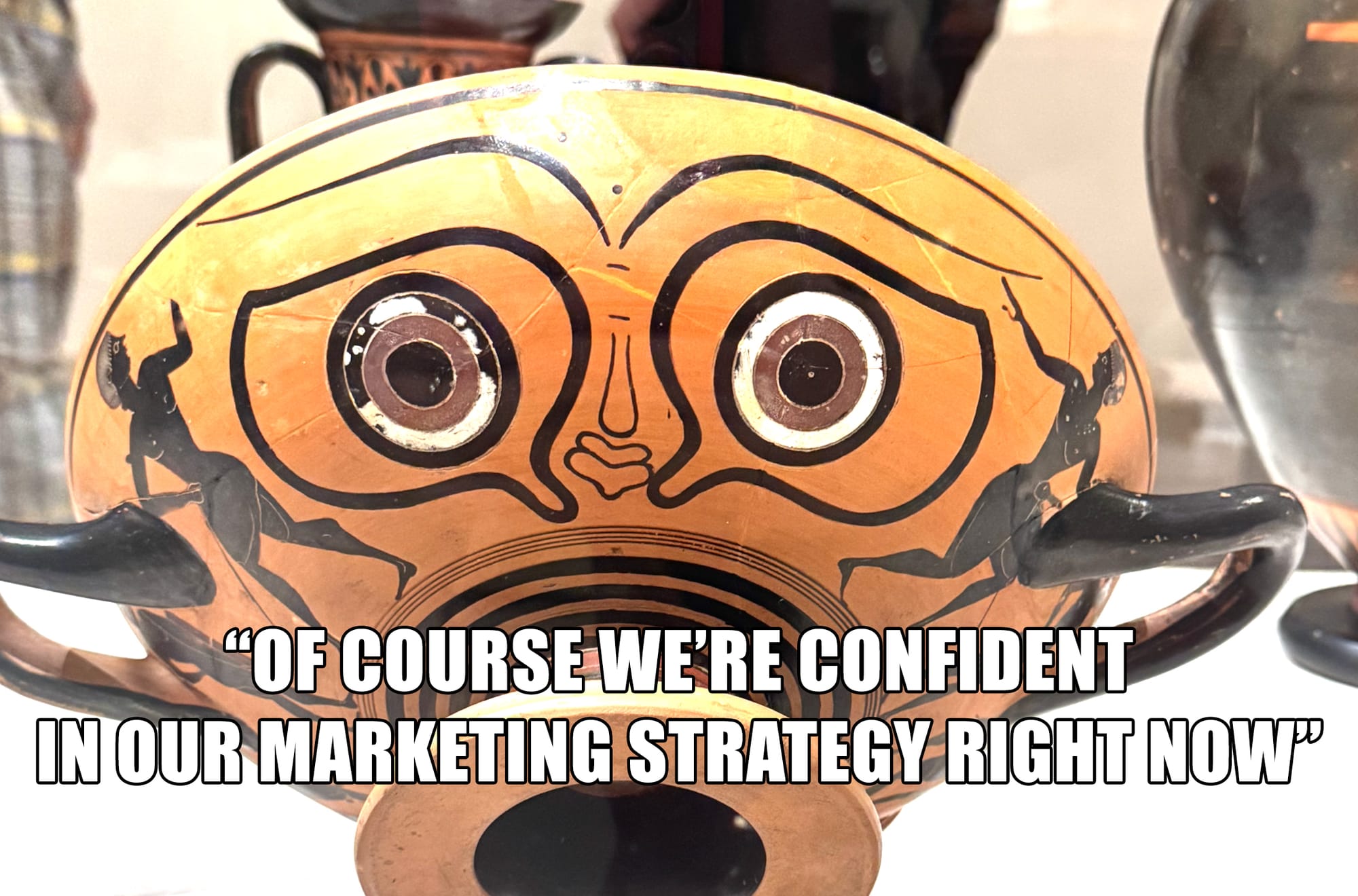 Photo of a silly looking ancient greek vase with a poker face captioned "of course we're confident in our marketing strategy right now"