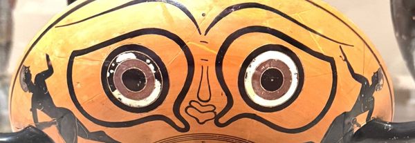 Zoomed in photo of a silly face on an ancient Greek vase.