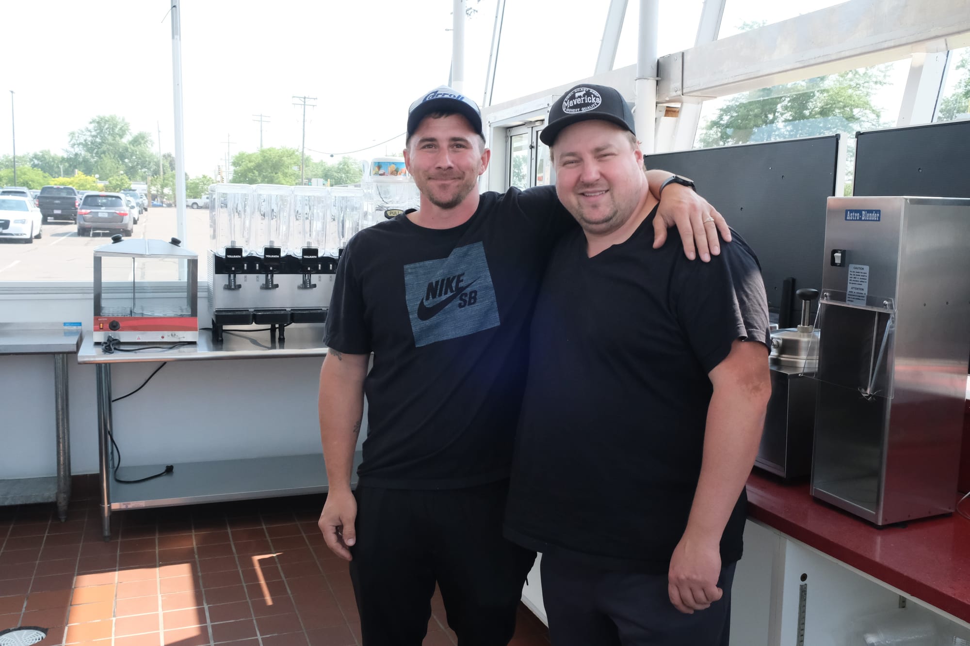 Curtis Thomspon and Timothy Hughes stand inside the new Sprinkles ice cream shop. They are both wearing ball caps and black tshirts.