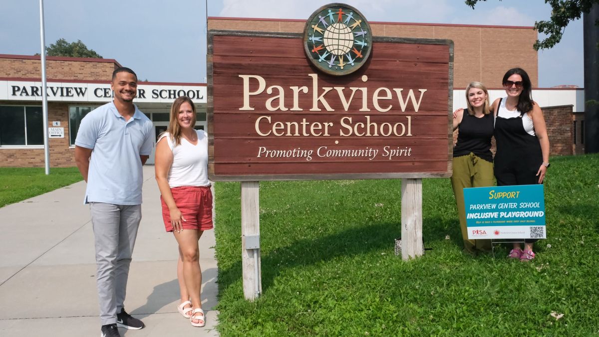 Parkview staff and parents stand in front of the Parkview Center School sign.