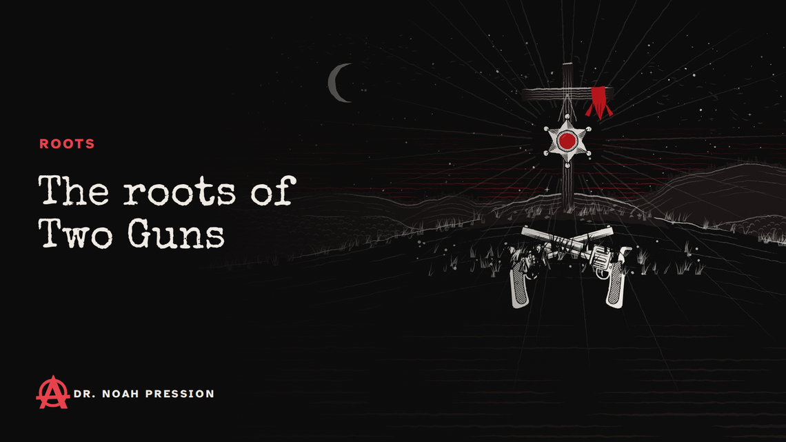 The roots of Two Guns: a grave cross with a sheriff's star and a red cloth on a hill at night, two crossed revolvers in the grass below.