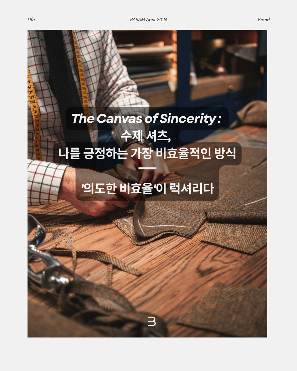 [BARAM Magazine] The Canvas of Sincerity. 체크무늬 셔츠를 입고 목에 줄자를 두른 재단사가 거친 나무 테이블 위에서 체크 패턴의 울 원단을 정교하게 만지고 있는 클로즈업 샷. 가위와 재단 도구들이 놓인 따뜻하고 빈티지한 분위기 속에 '의도한 비효율이 럭셔리다'라는 문구가 배치된 매거진 화보
