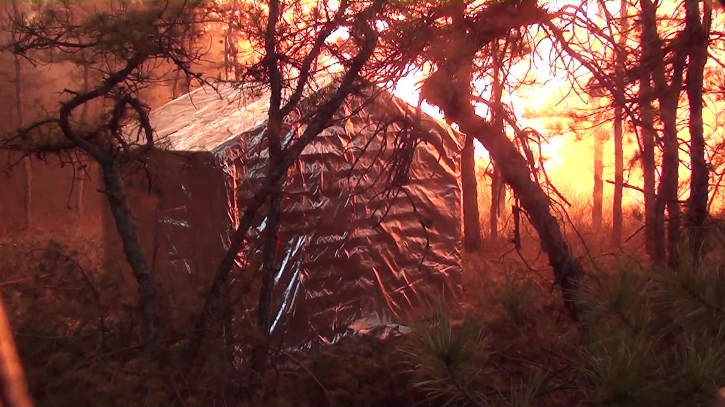 Aluminized wrap on a small test structure with the flame front burning directly behind it, 2011 burn test