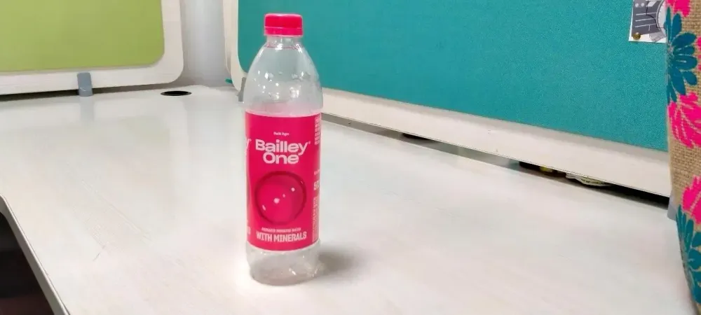 A bottle of water on a white surface
Description automatically generated