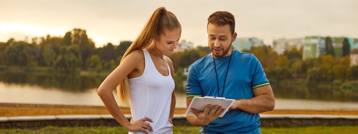 A fitness coach discussing the training plan with his client.