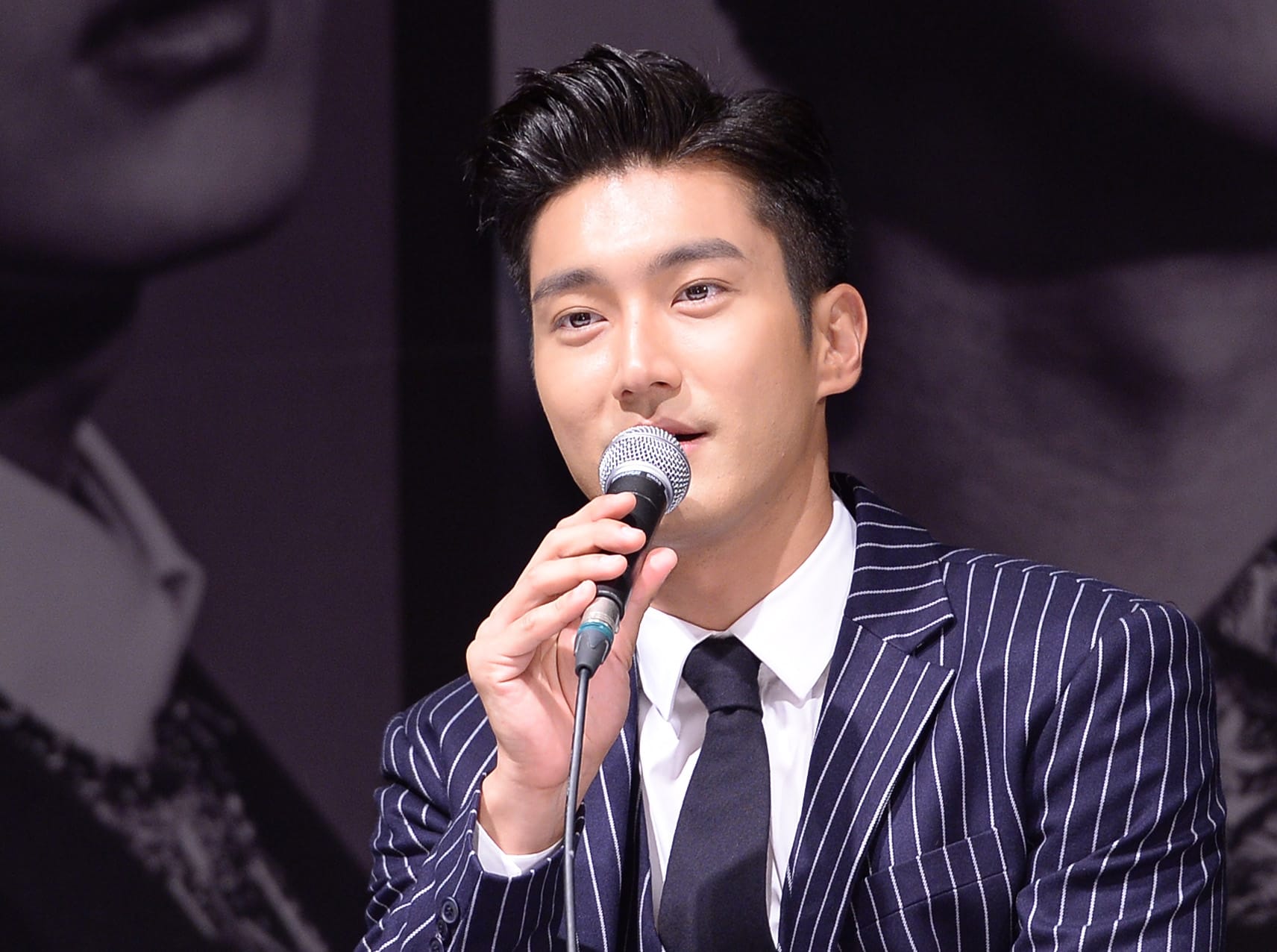 K-pop artist Choi Siwon of Super Junior speaking into a microphone at a press event — known for openly expressing his Christian faith