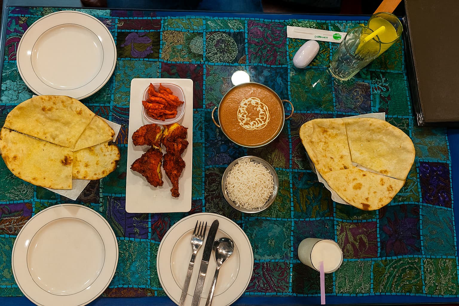 Top-down view of butter chicken, naan, rice, and tandoori chicken at Baraji Indian Restaurant in Daegu