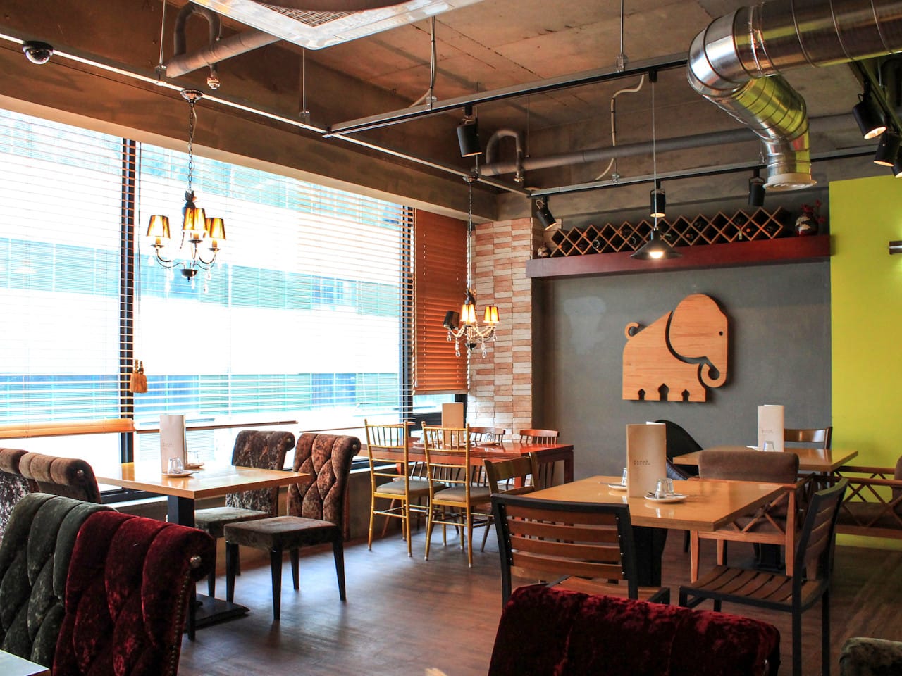 Cozy and stylish interior of Rama & Bavana Sangin, an Indian restaurant in Daegu with wooden elephant wall art and modern lighting