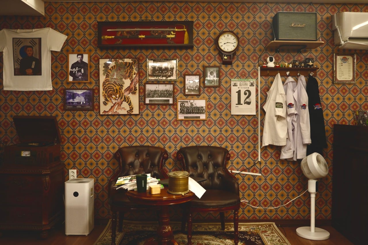 Vintage interior of 1919 Barbershop in Gwangju, Gyeonggi, featuring classic Korean décor, leather chairs, framed historical photos, and antique furnishings