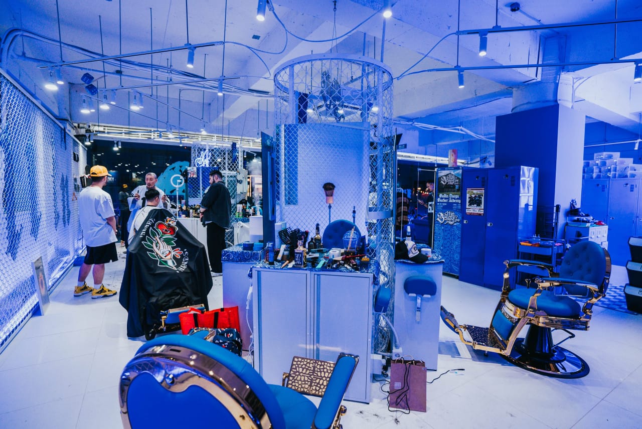 Modern interior of Ballin Barbershop in Daegu with barbers working on clients, featuring luxury barber chairs, stylish décor, and professional grooming tools