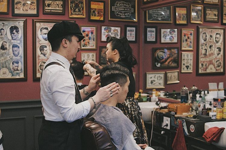 Barber at Jackson Pama Barbershop in Busan giving a classic fade haircut to a male client, known for expert cuts, specialty styles, and English-friendly service