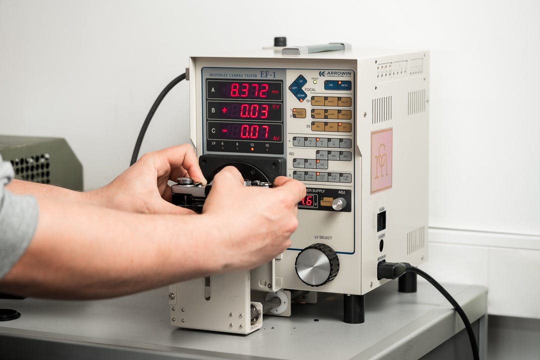 Man holding a camera up to a Multiplex camera tester