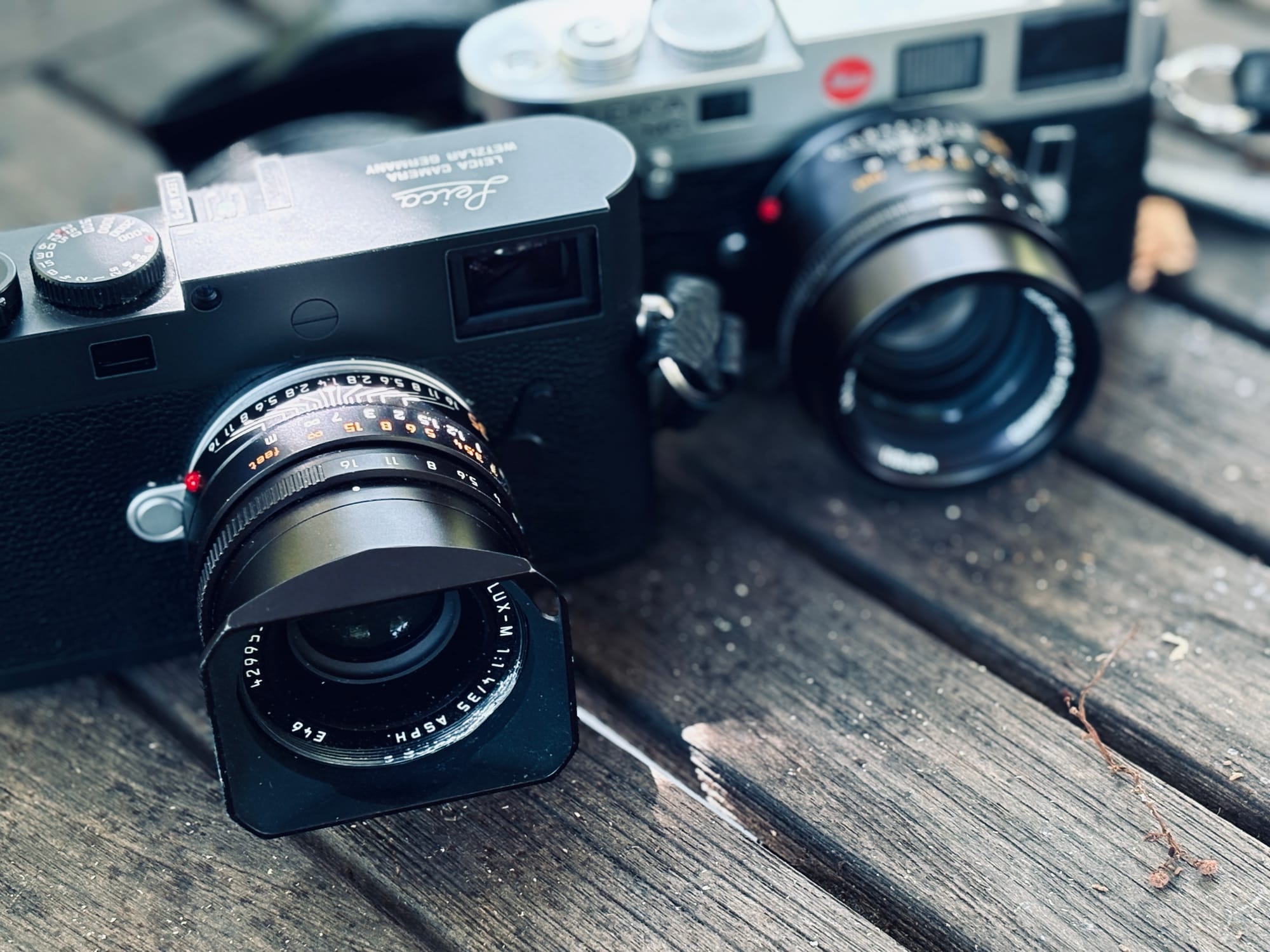 two Leica cameras, one digital and one film, side-by side