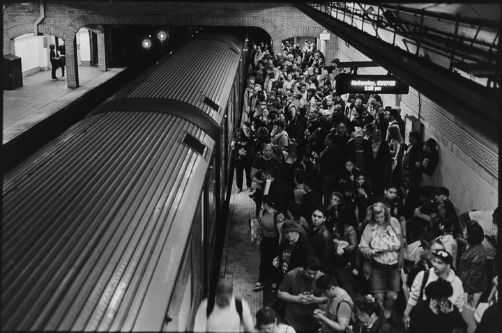 overhead view of a crowded subway platform with a train in the staion
