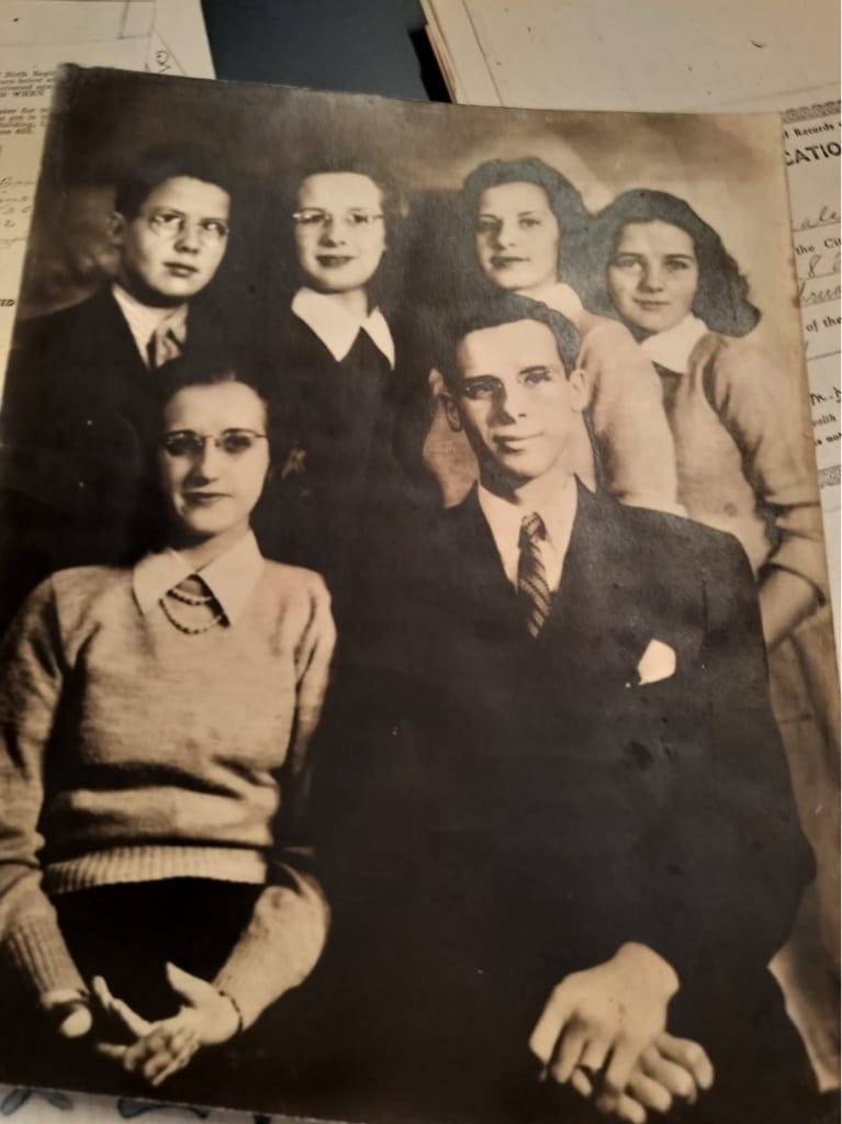 Black-and-white 1938 family photograph of six siblings posed in two rows