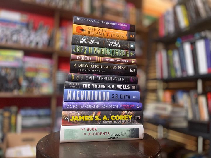 A tall stack of books sitting on a stool