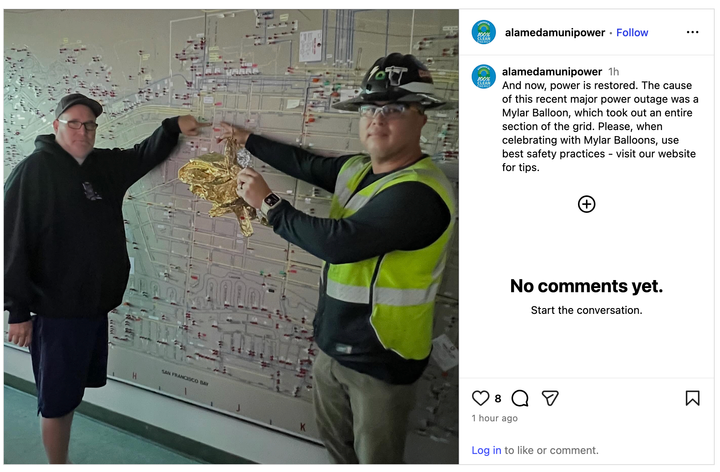 @alamedamunipower post on Instagram featuring a photo of two staff members holding a deflated golden balloon in front of a circuit map of Alameda