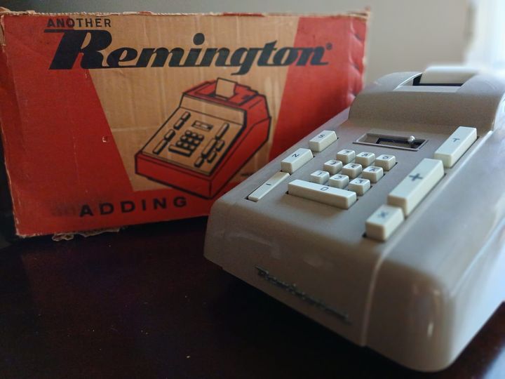 Vintage Remington adding machine beside its original box