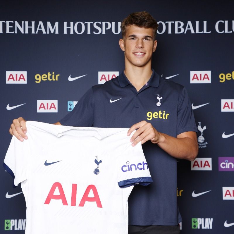 Luka Vušković holds up a Spurs shirt at his contract signing.