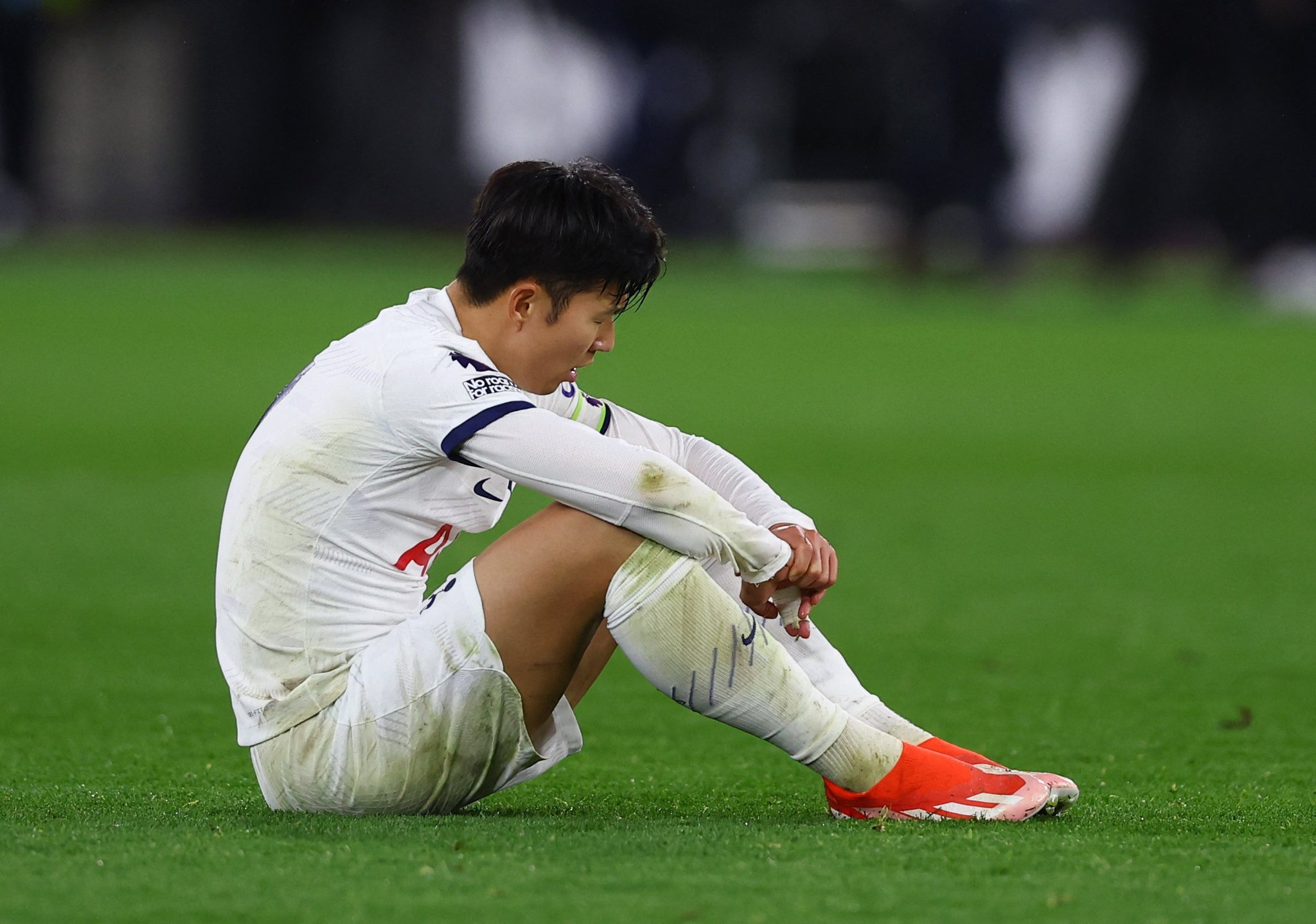 Son Heung-min sits down with his arms on his knees.