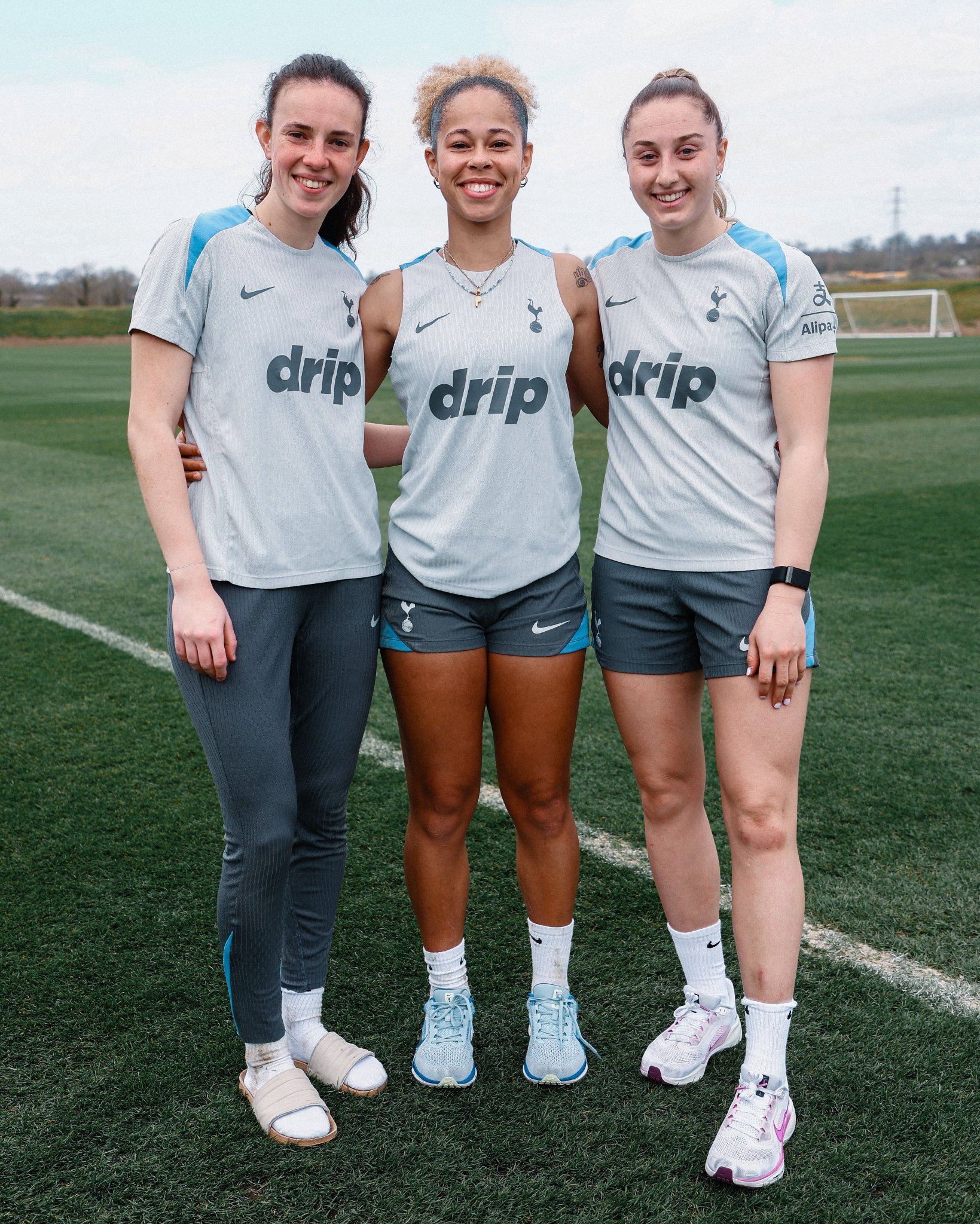 U23s Lionesses Eleanor Heeps, Lenna Gunning-Williams, and Ella Morris pose together for a photo at the training pitch.