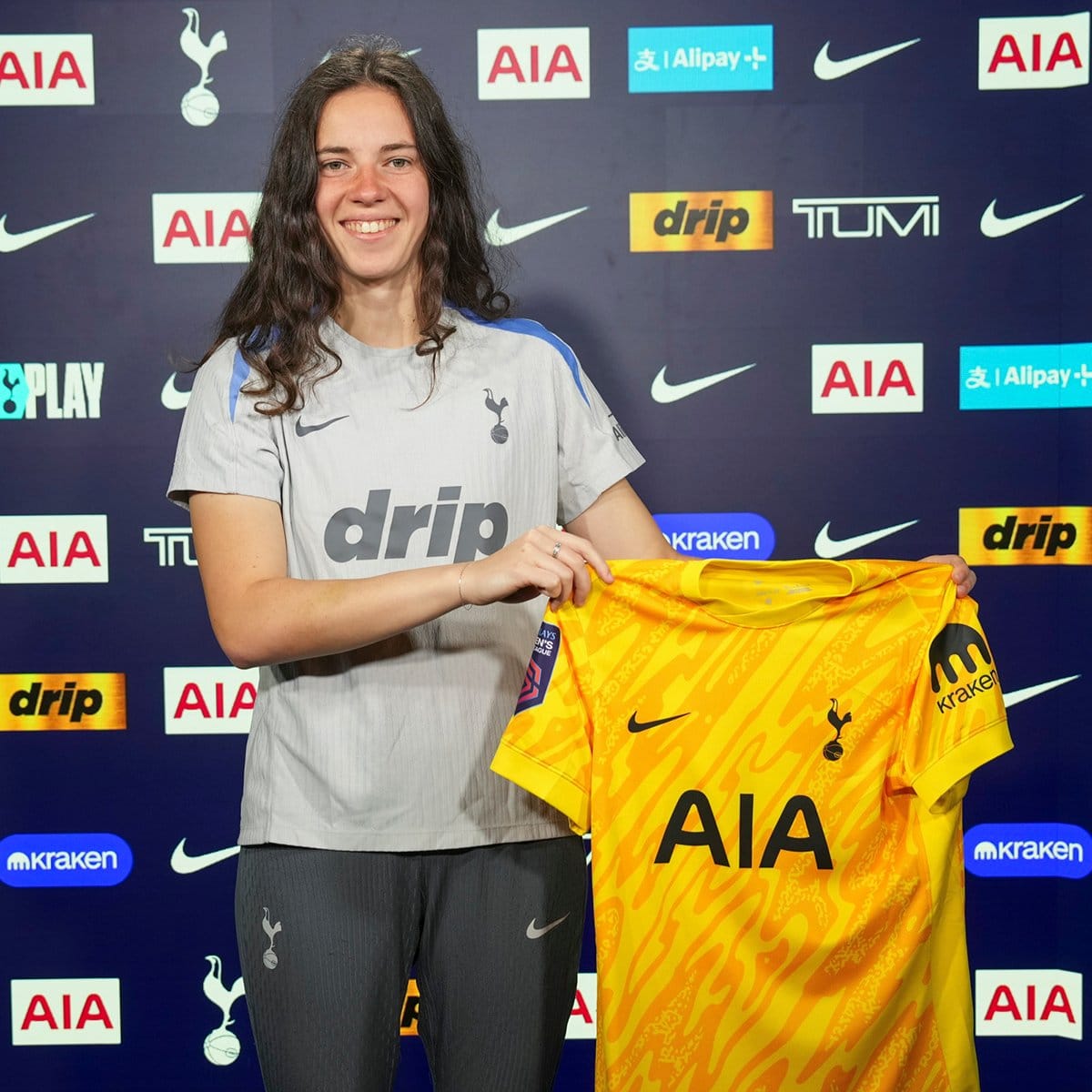 Eleanor Heeps holds up a Spurs shirt after signing her new contract.
