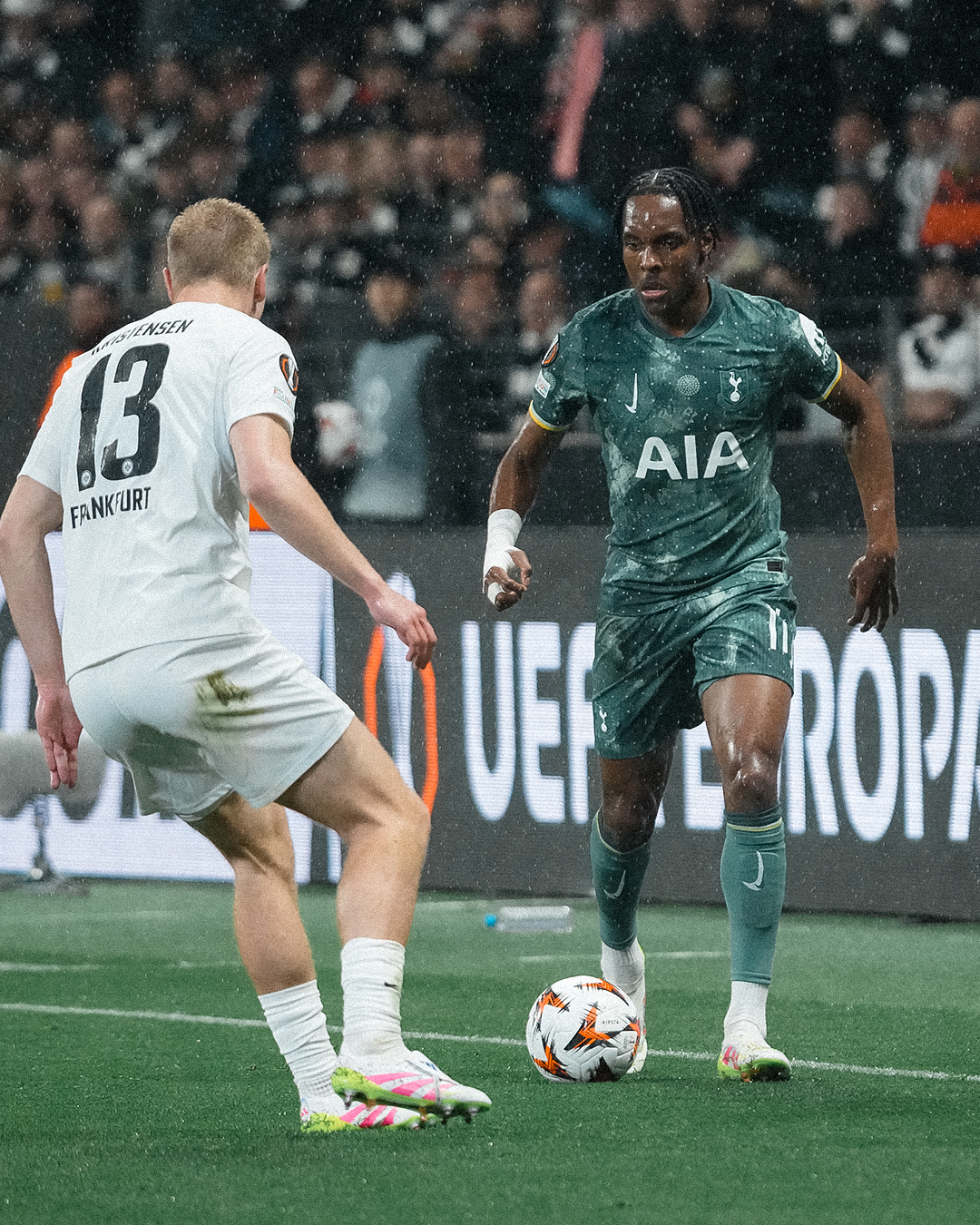Mathys Tel dribbles the ball in the rain. 