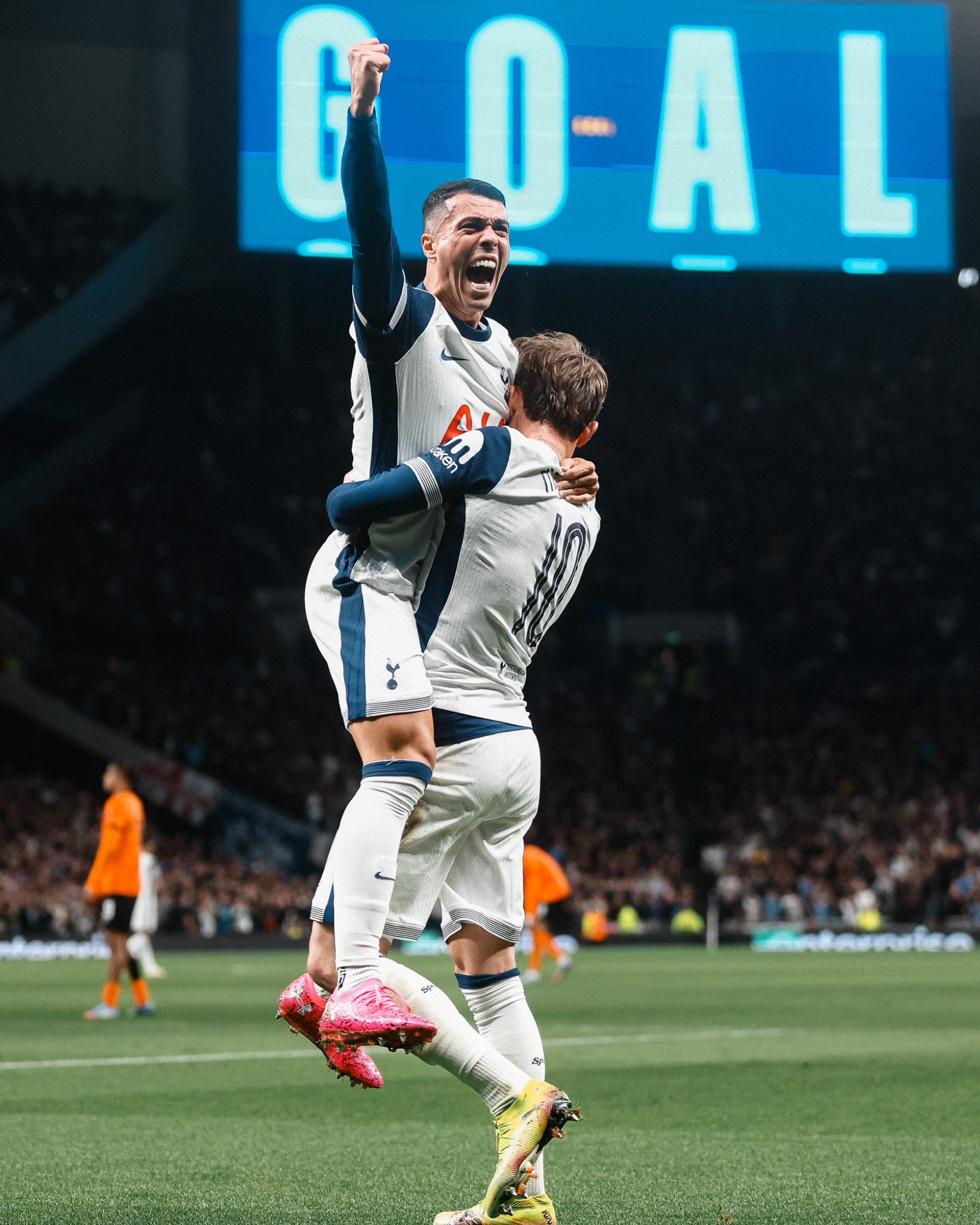 Pedro Porro jumps into James Maddison's arms to be lifted as he raises his right arm in a fist.