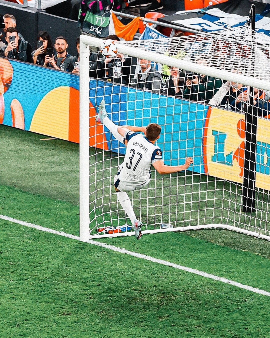 Micky van de Ven leaps into the air to acrobatically clear the ball from going over the goal line. 