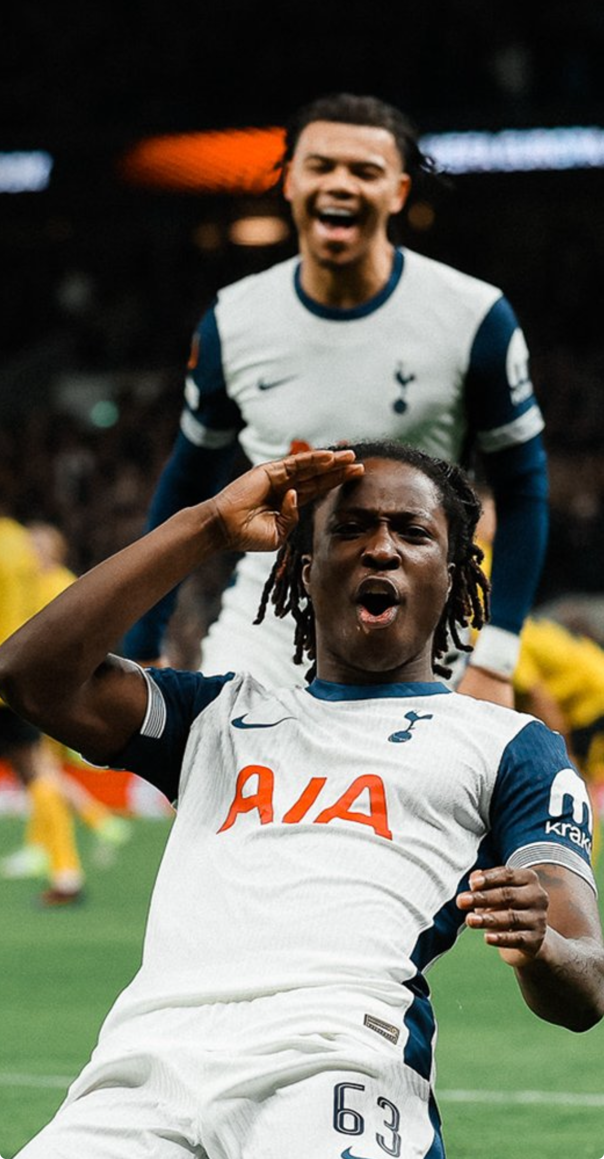 Damola Ajayi does a knee slide and salutes to celebrate his first Spurs goal as Dane Scarlett runs up behind him.