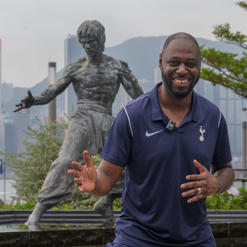 A smiling Ledley King strikes a similar pose to the statue of Bruce Lee behind him.