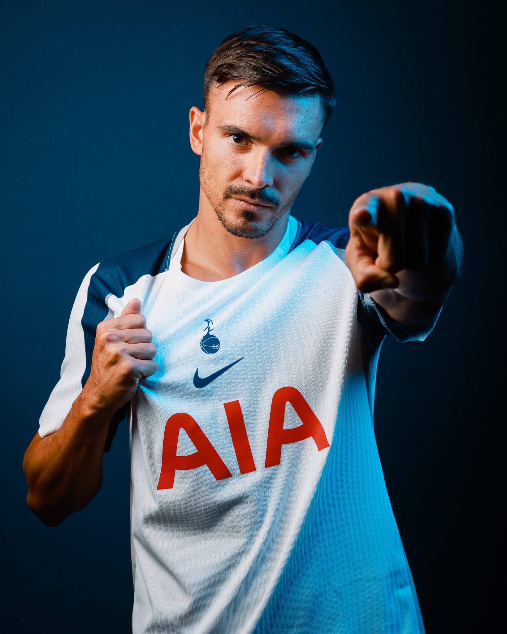 João Palhinha graps the home kit in one hand and points at the camera with the other.