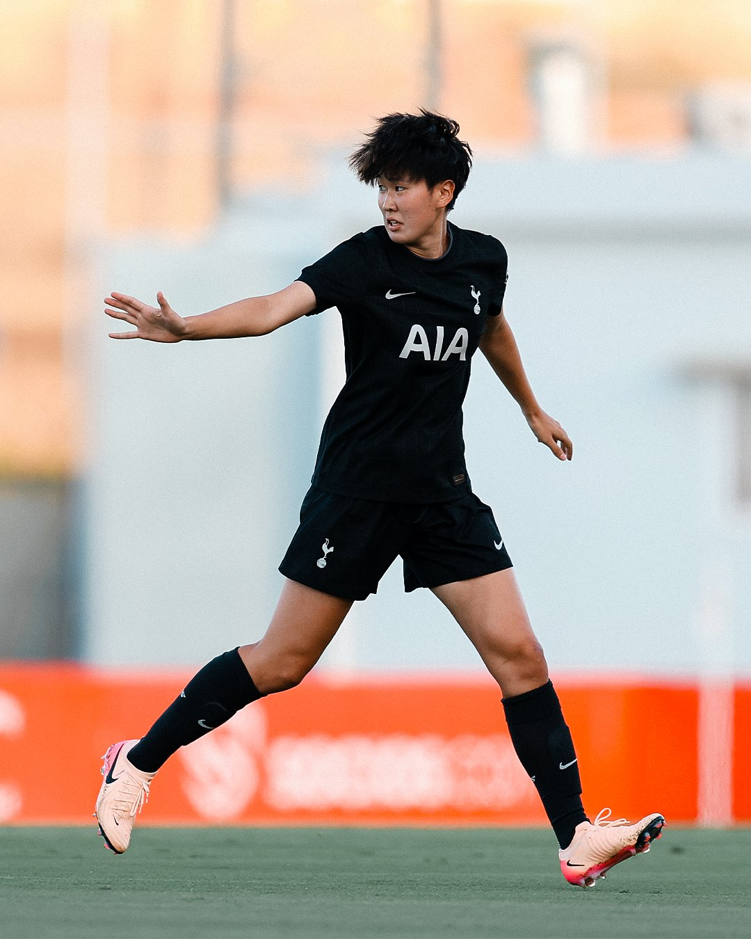 Tōko Koga holds up a hand as she runs.