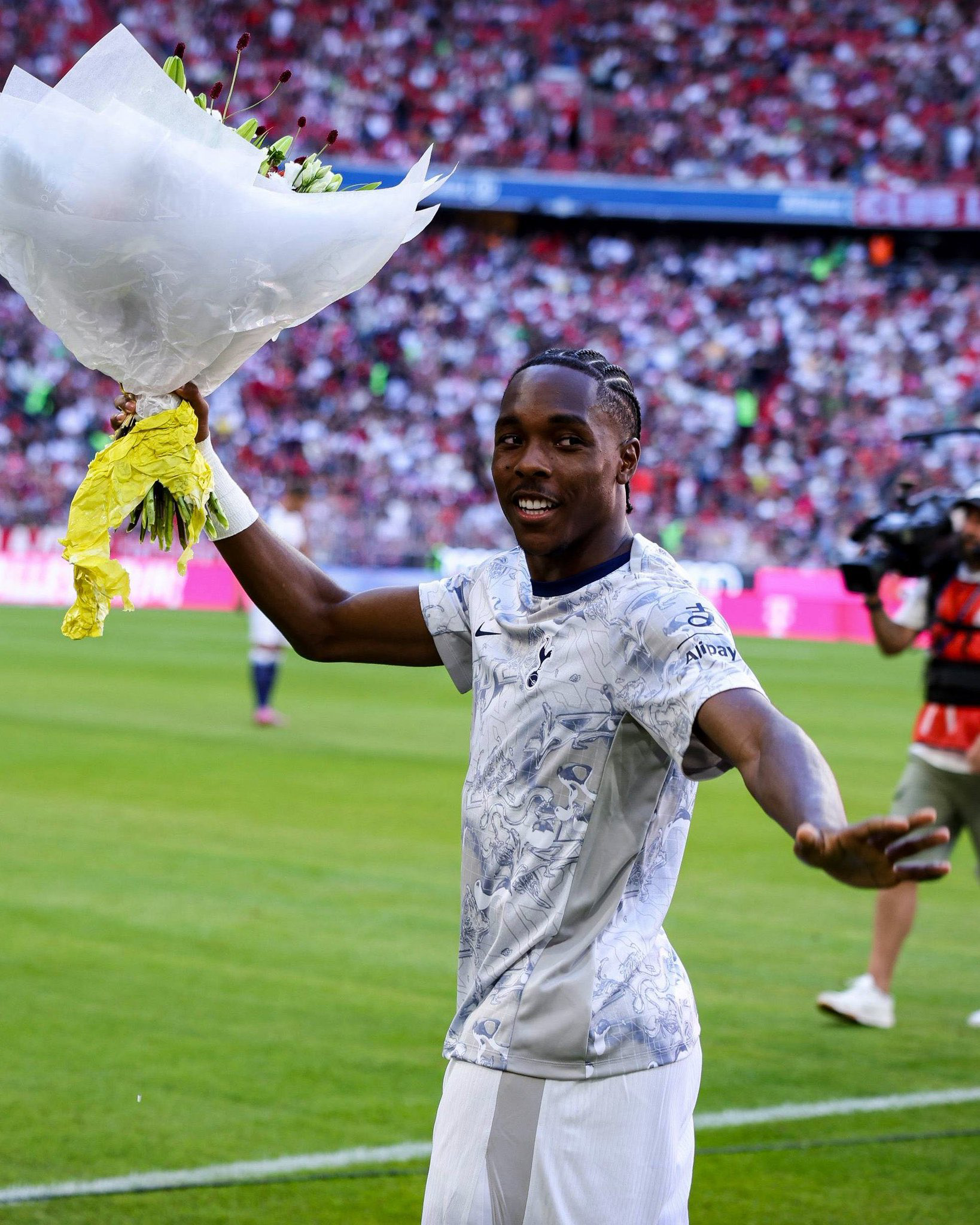 Mathys Tel waves to his former fans at Bayern, with a bouquet of flowers in hand.