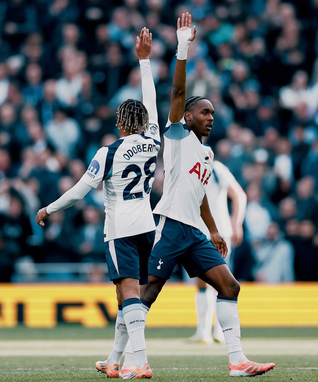 Wilson Odobert, back to the camera, and Mathys Tel pass by each other after a high five, hands still aloft.