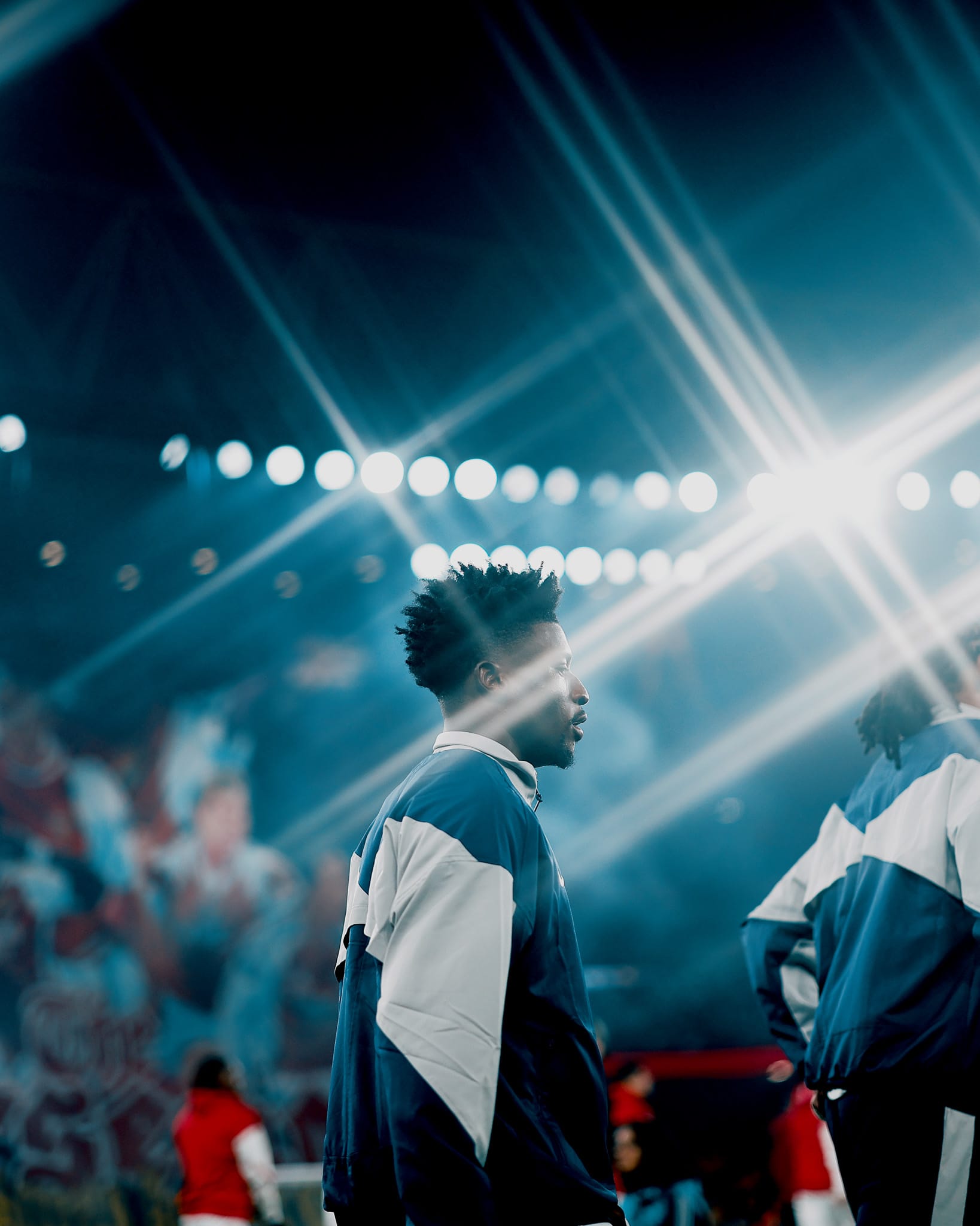 Mohammed Kudus, in his training jacket, is surrounded by light flares from the stadium lights.
