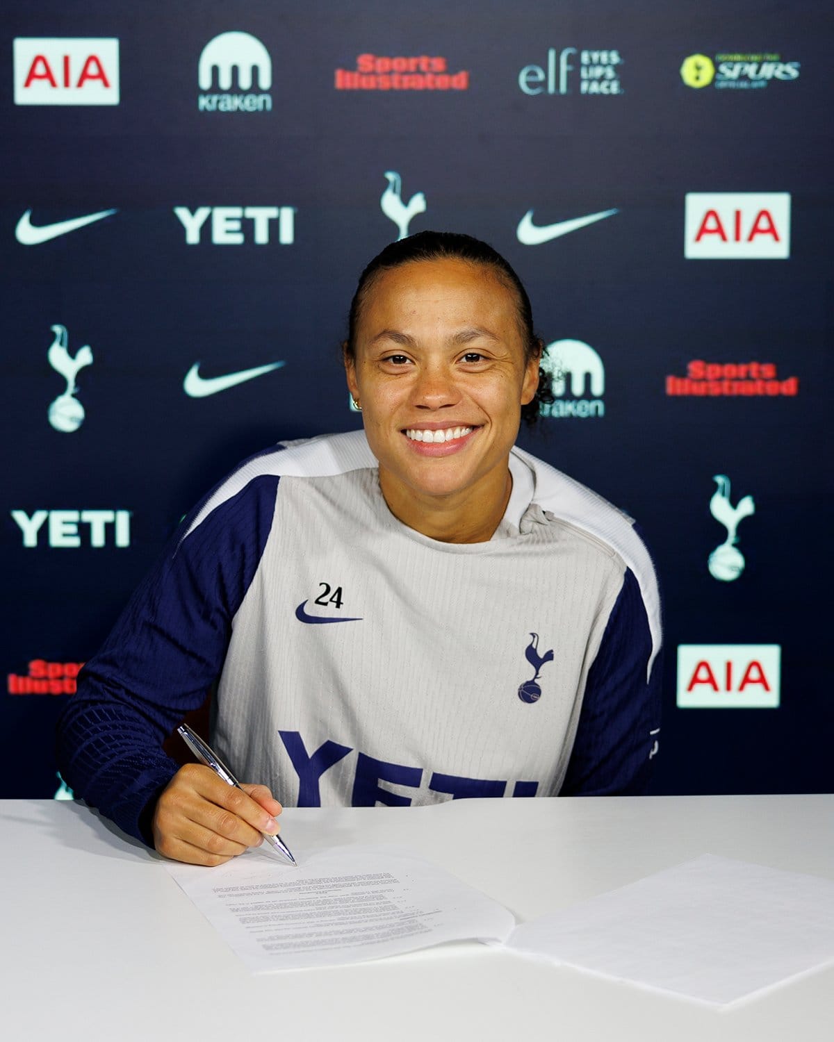 Drew Spence signs her new contract.