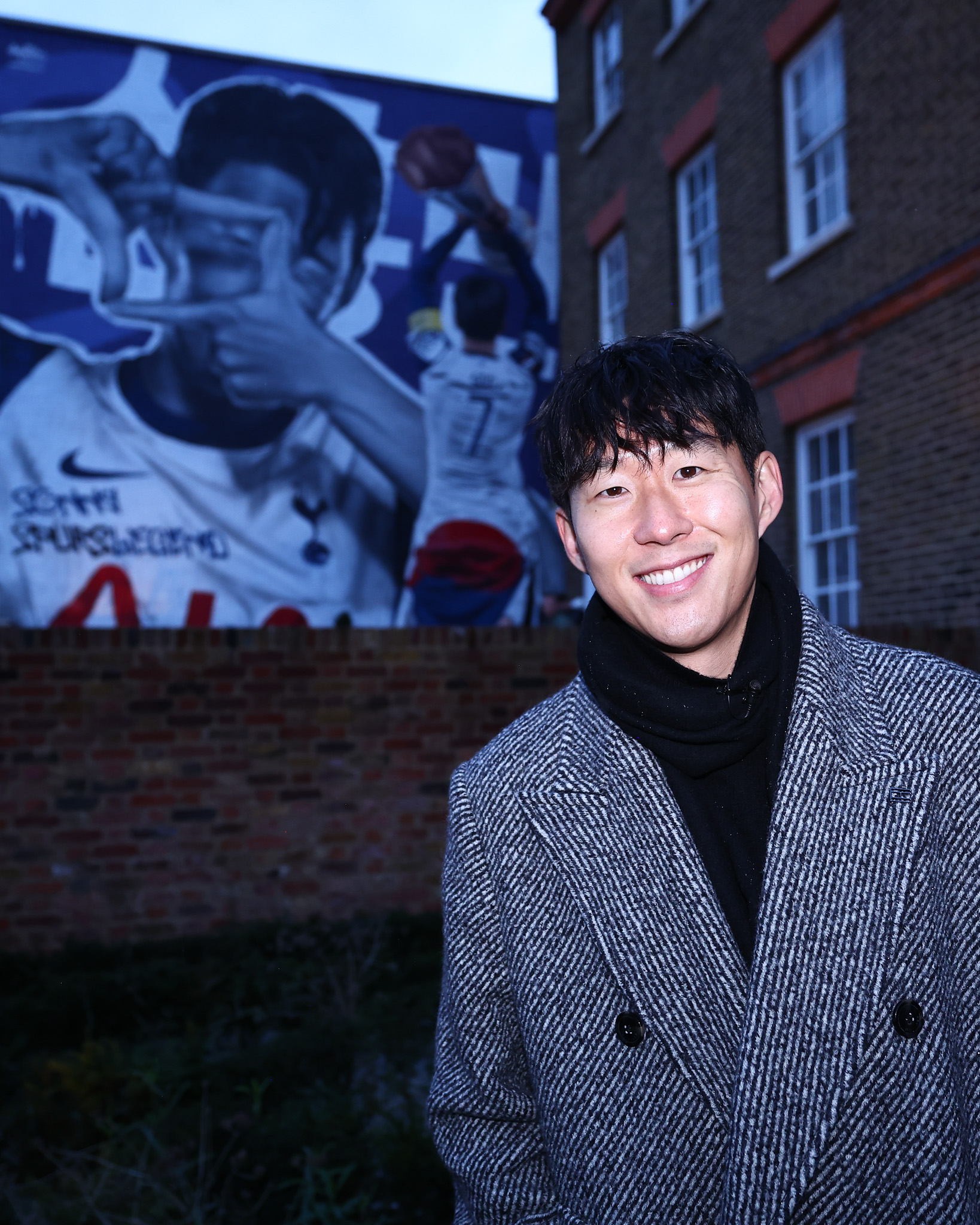 Son Heung-min smiles in front of his new mural on the Tottenham High Road.
