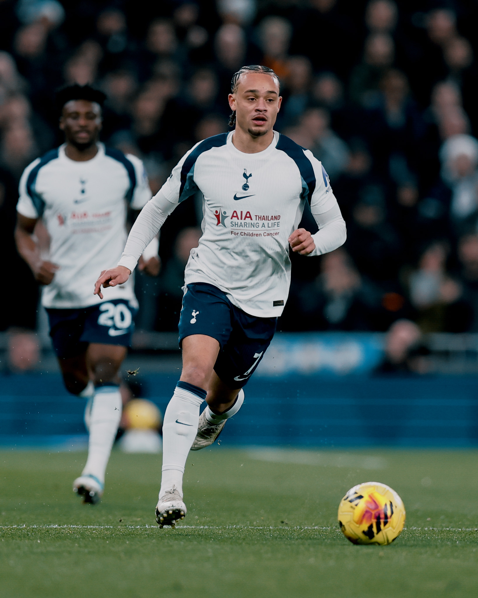 Xavi Simons scans ahead of him as he dribbles.