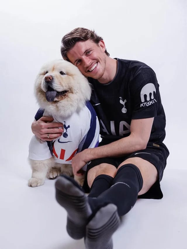 Conor Gallagher sits in his black away kit with an arm around his chow chow, Freddy.