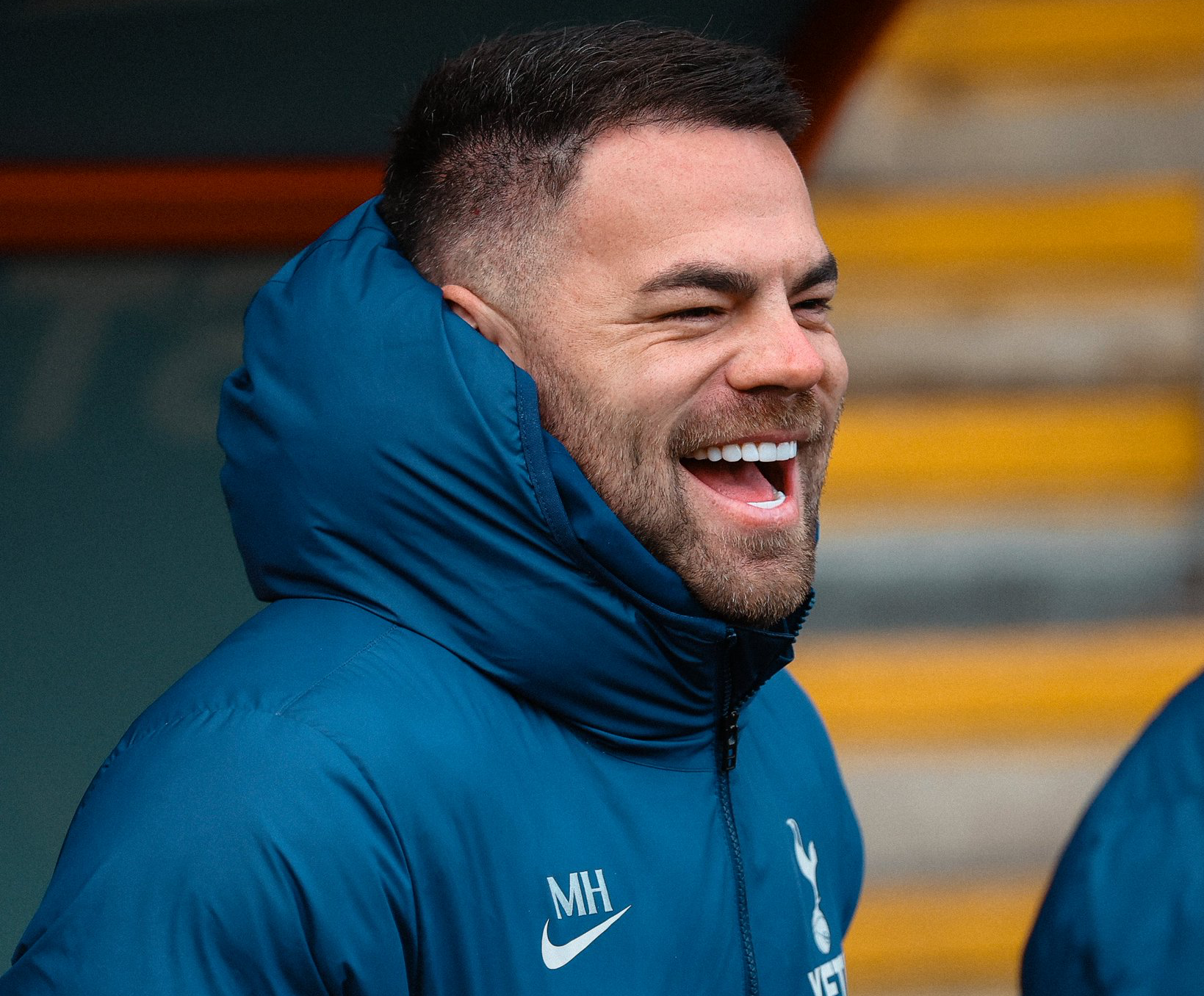 Martin Ho laughs in his club-issued puffer jacket.