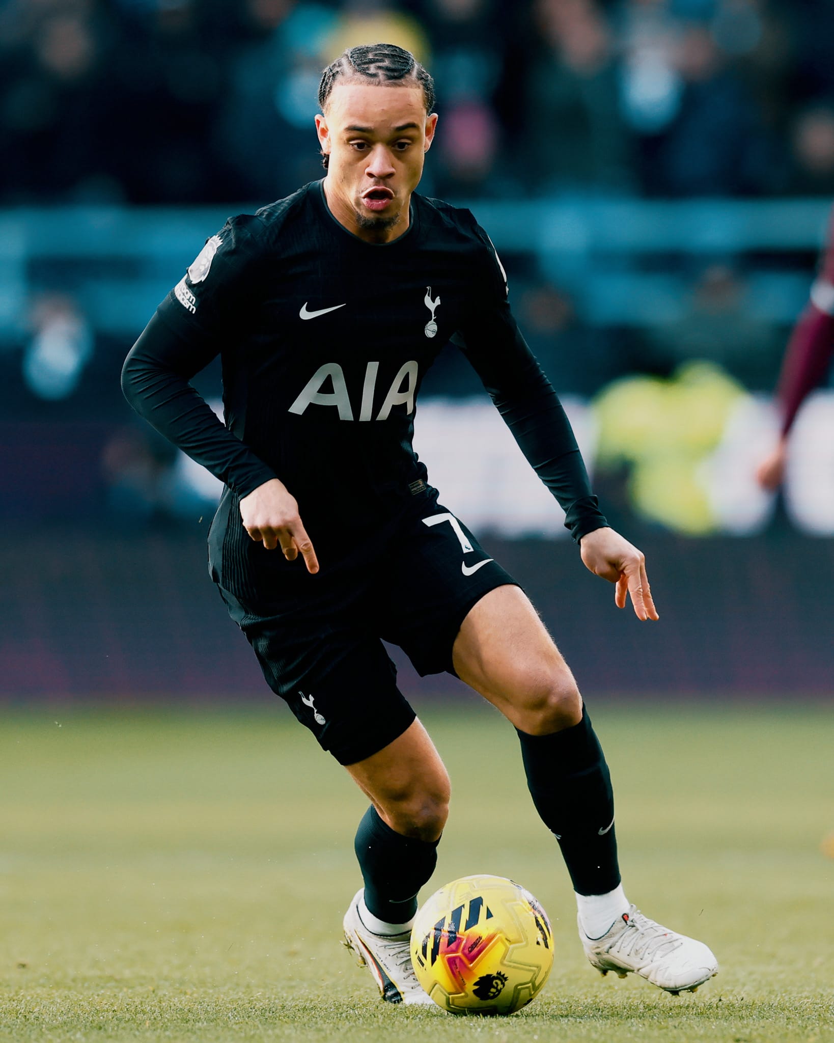 Xavi Simons dribbles the ball with a look of deep concentration.