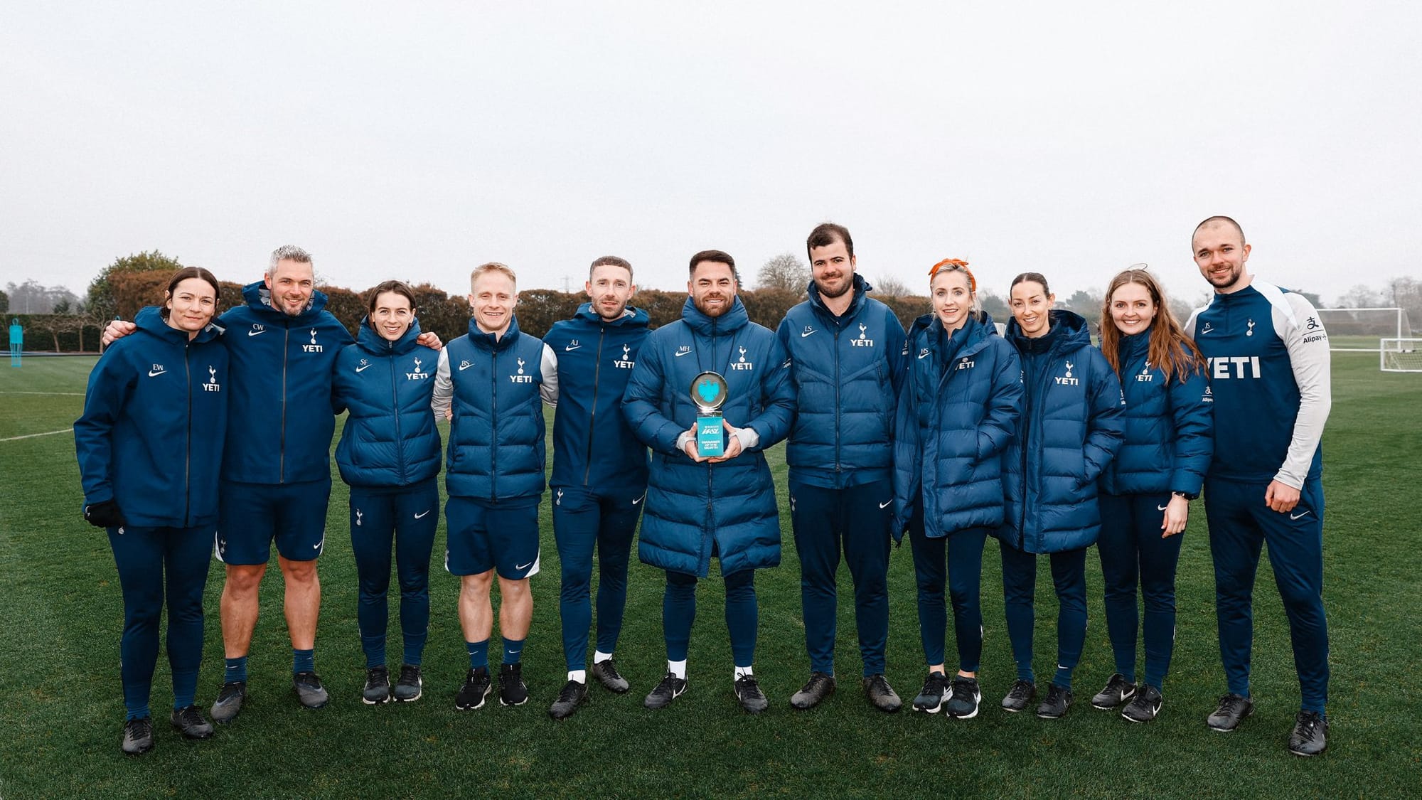 Martin Ho poses with his Manager of the Month trophy alongside his coaching staff.
