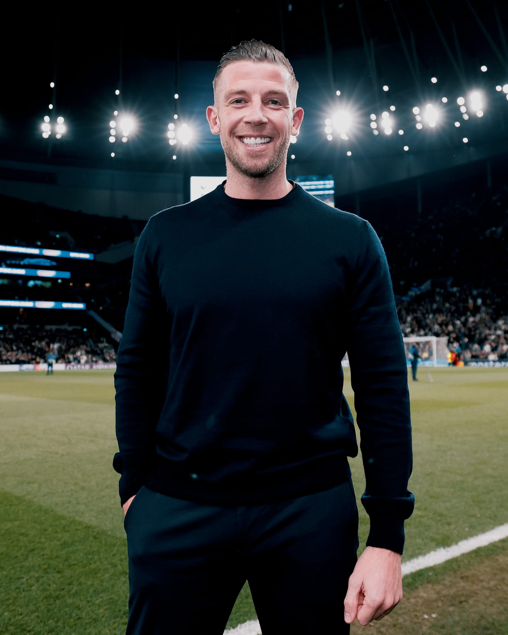 Toby Alderweireld smiles on the pitch at Tottenham Hotspur Stadium.