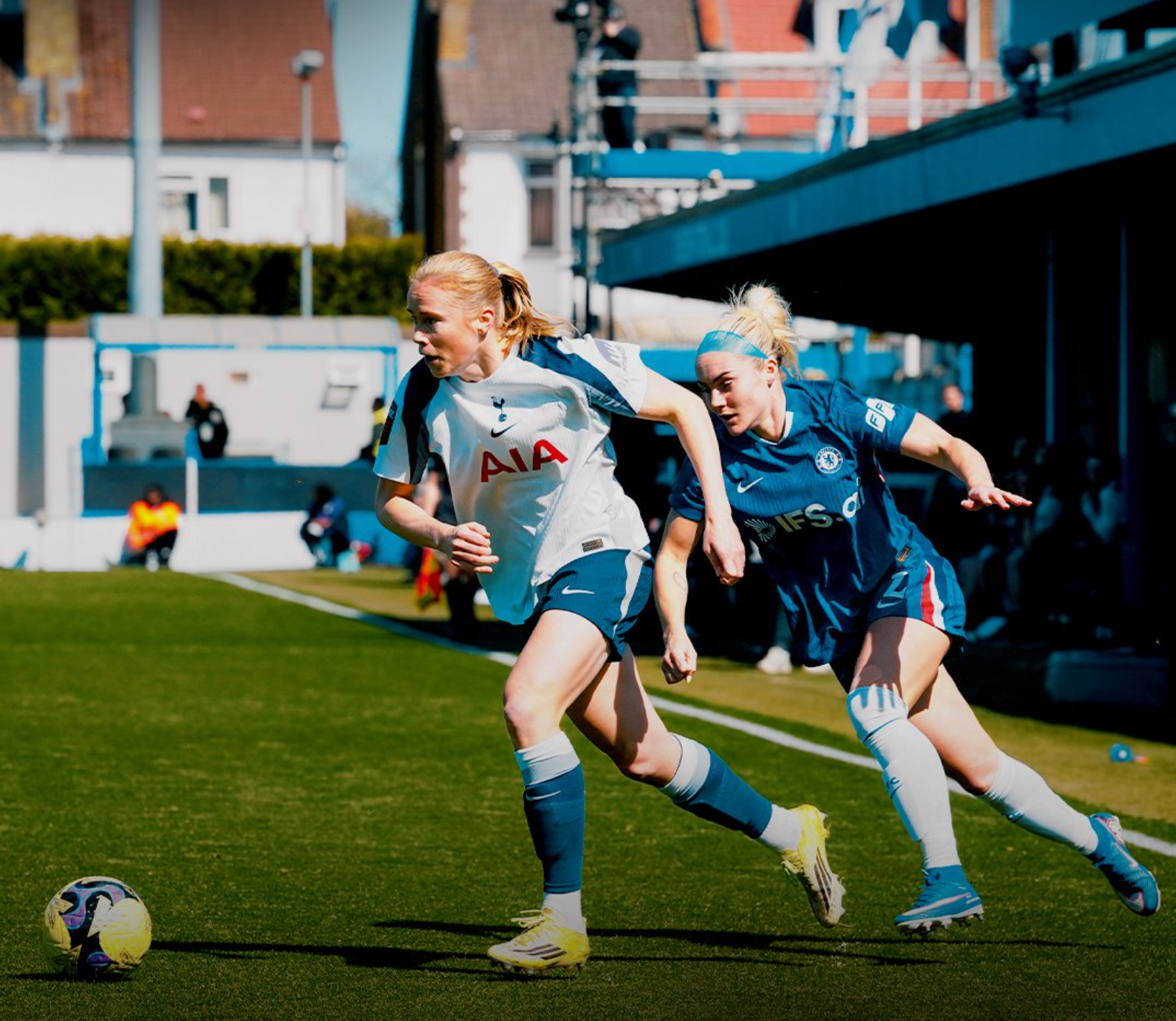 Julie Blakstad dribbles the ball away from Ellie Carpenter behind her.
