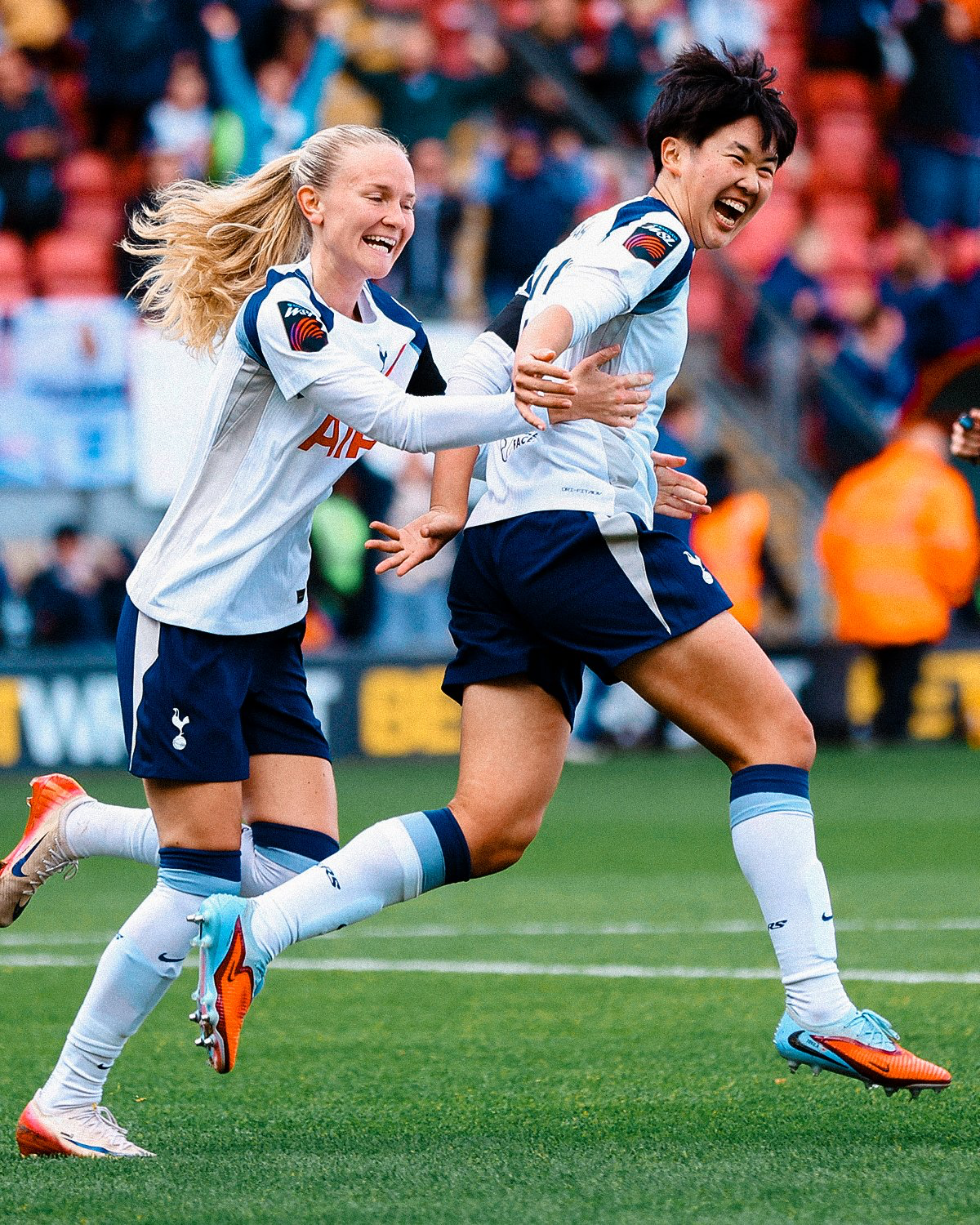 Tōko Koga smiles and is hugged by Tilly Vinberg while celebrating a goal.